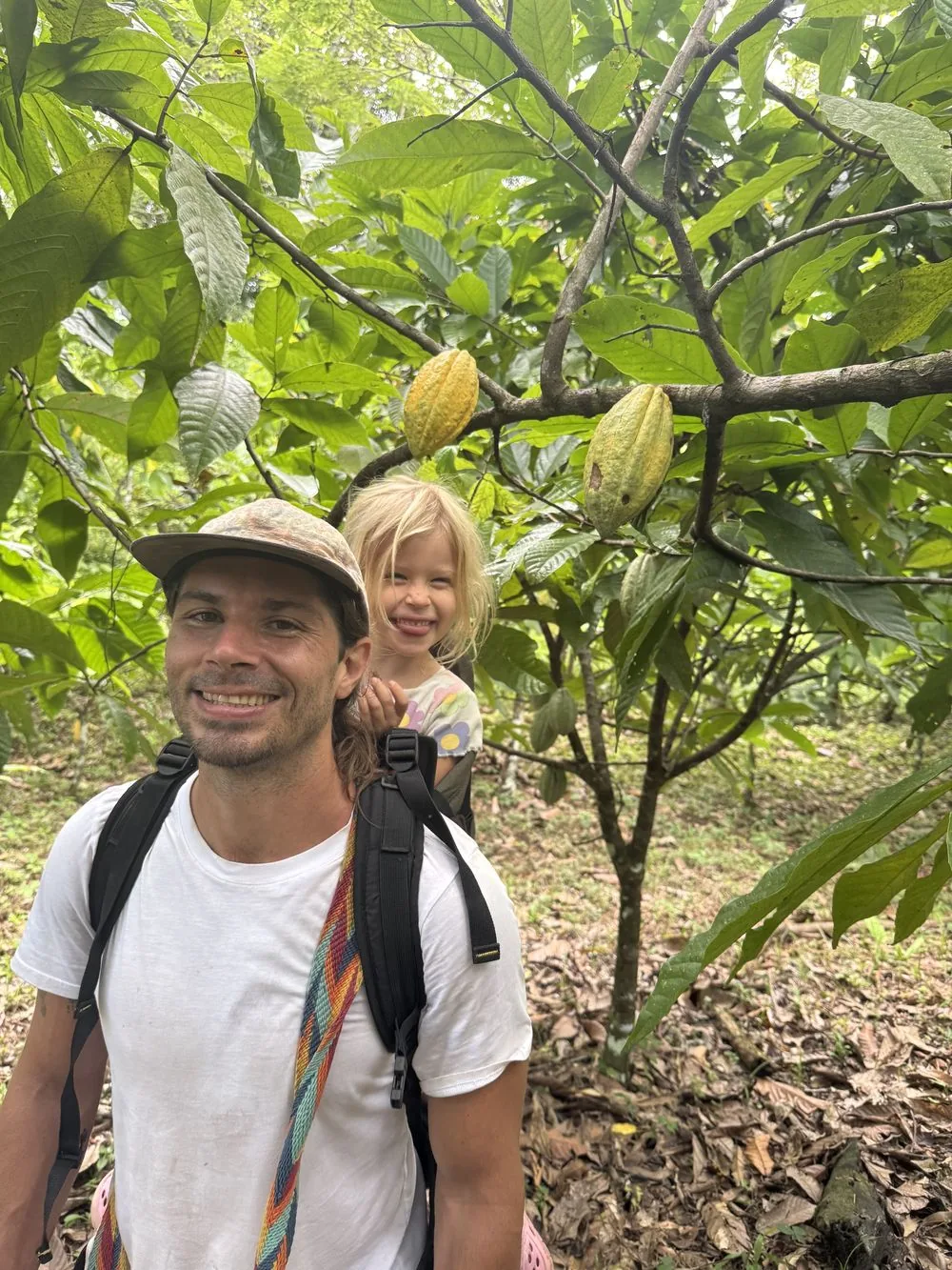 Michael carrying his daughter through a Costa Rican cacao grove